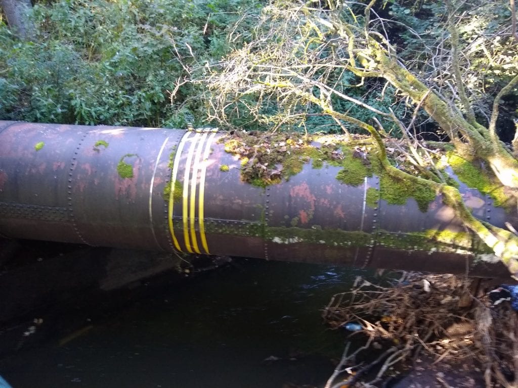 A pipe bridge leaking from rusting joints before undergoing a SylWrap repair and and reinforcement