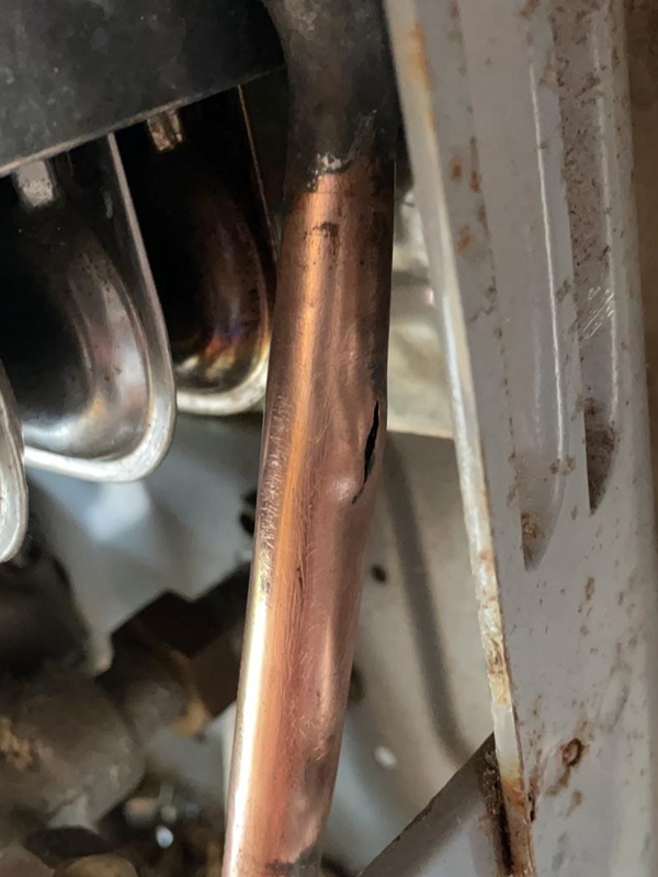 A crack in a copper pipe which was part of a camper van boiler system before undergoing repair using a Sylmasta Pipe Repair Kit