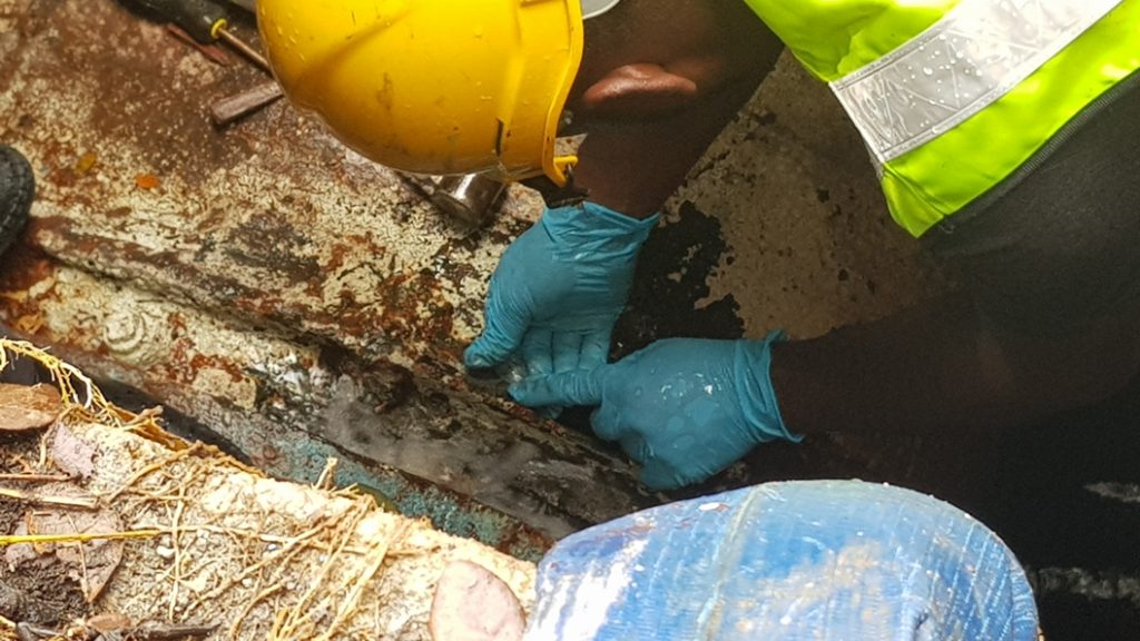 An engineer applies Superfast Steel Epoxy Putty Stick to a cracked 900mm steel water main during a repair in Malaysia