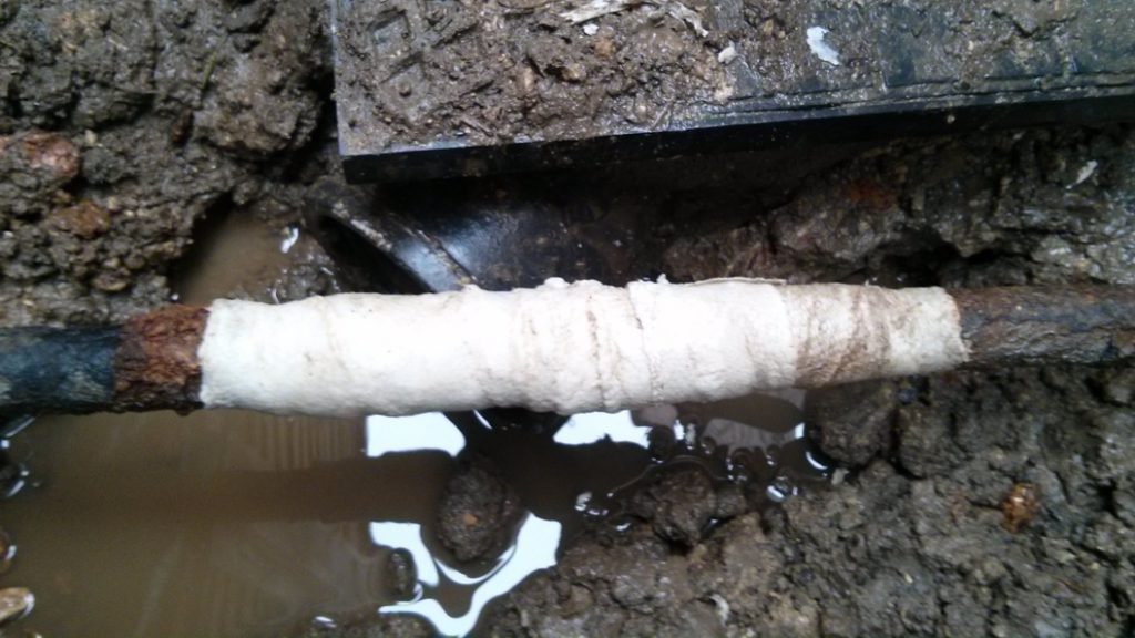 Repair of a 90-year-old cracked malleable iron water supply pipe made using a SylWrap Standard Pipe Repair Kit