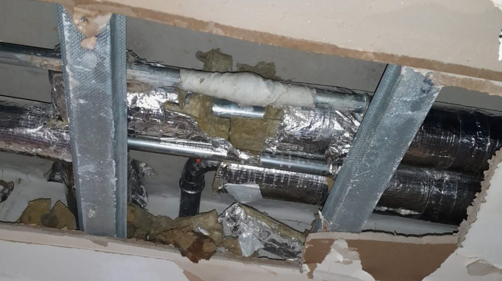 Completed repair of a steel pipe in a district heating system suspended in the ceiling of a building