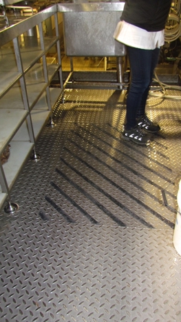 A stainless steel floor prior to having a new anti slip flooring surface applied using an epoxy coating