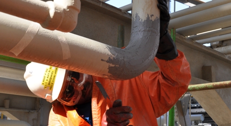 Epoxy paste being used to rebuild a degraded sulphuric acid line as part of a repair and maintenance application in Saudi Arabia