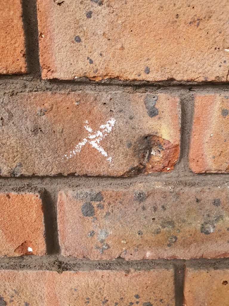 Chuck of brick missing through lime blow prior to repair using epoxy putty
