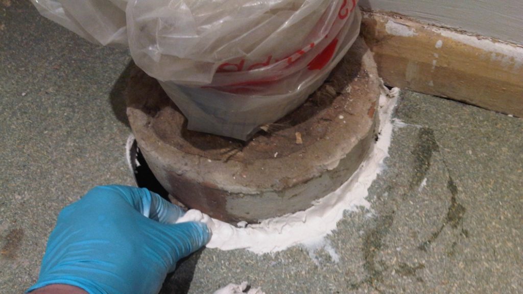 Epoxy putty used to full in cracks between a toilet waste pipe and a bathroom floor in a repair required during renovation work