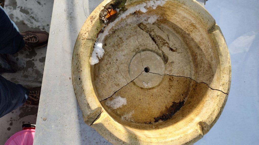 A badly cracked bowl from a composite stone water fountain before undergoing a Sylmasta repair