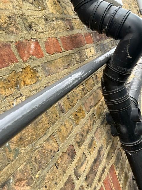 Liquid Metal applied during the repair of a section of shared water supply running awkwardly behind a gutter down section