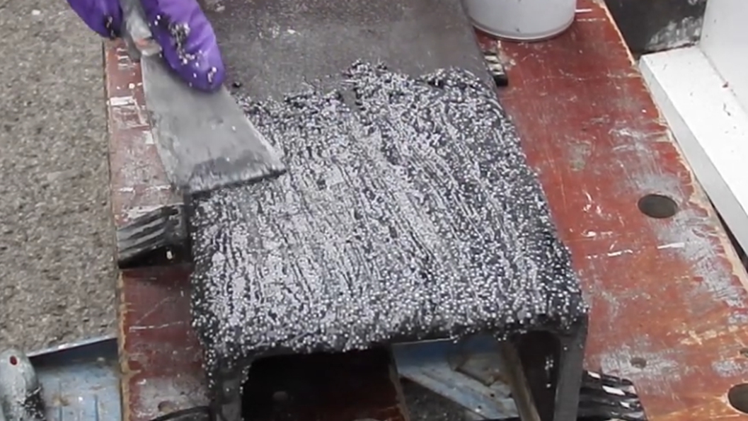 WearShield Epoxy Paste being applied to a metal demo piece to show it is highly resistant to abrasion and wear