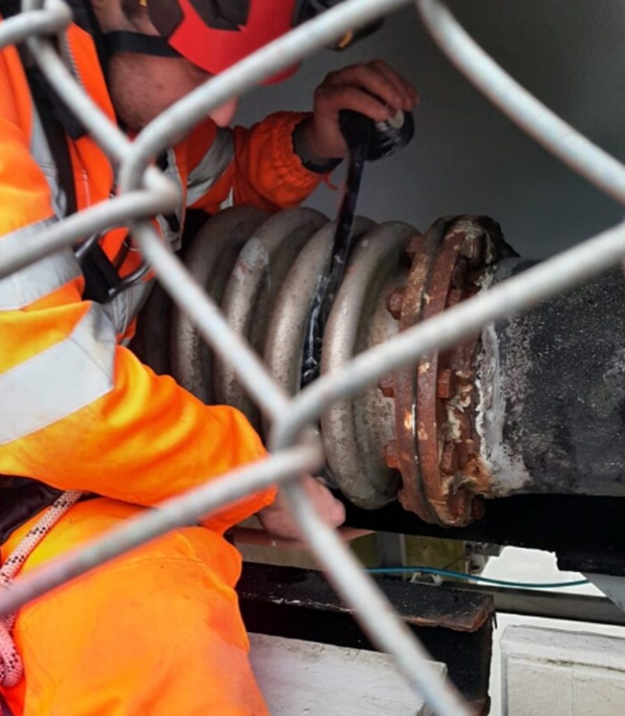 Engineers apply Wrap & Seal Pipe Burst Tape during the repair of a 225mm steel water pipe expansion joint