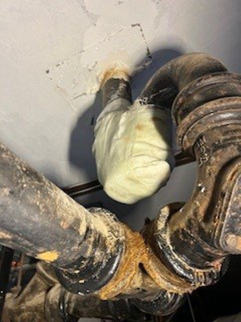 Cast iron pipe U-bend with hairline crack undergoes repair at a UK hospital with SylWrap Pipe Repair Bandage