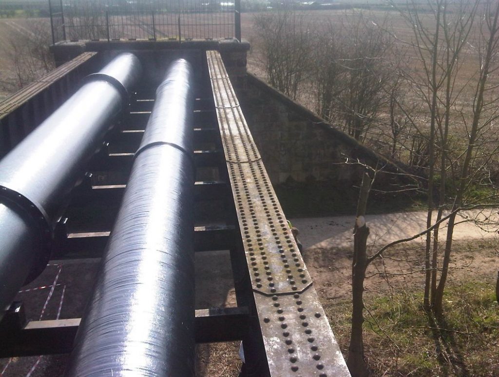 Liquid Metal Epoxy Coating and SylWrap CR Corrosion Protection Wrap used in the reinforcement of a corroded pipe bridge