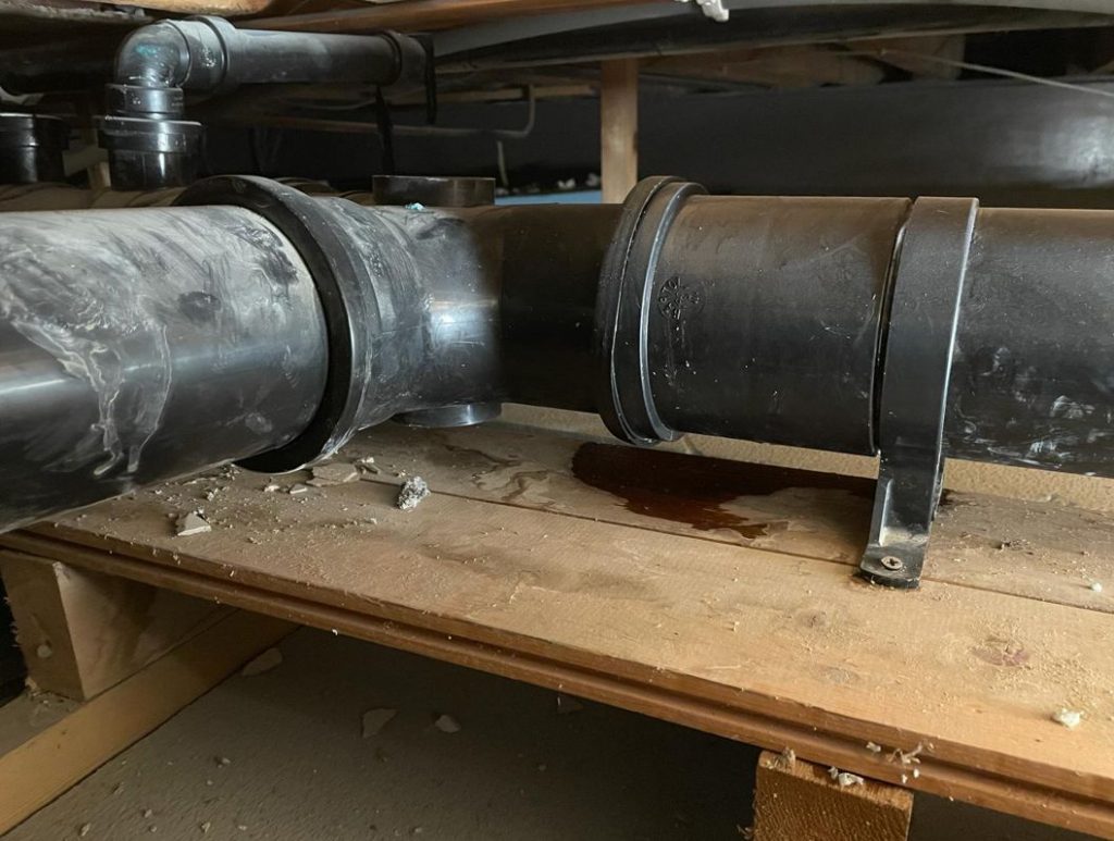 Plastic pipe joint leak in the confined loft space of a house in the United Kingdom before undergoing a SylWrap repair