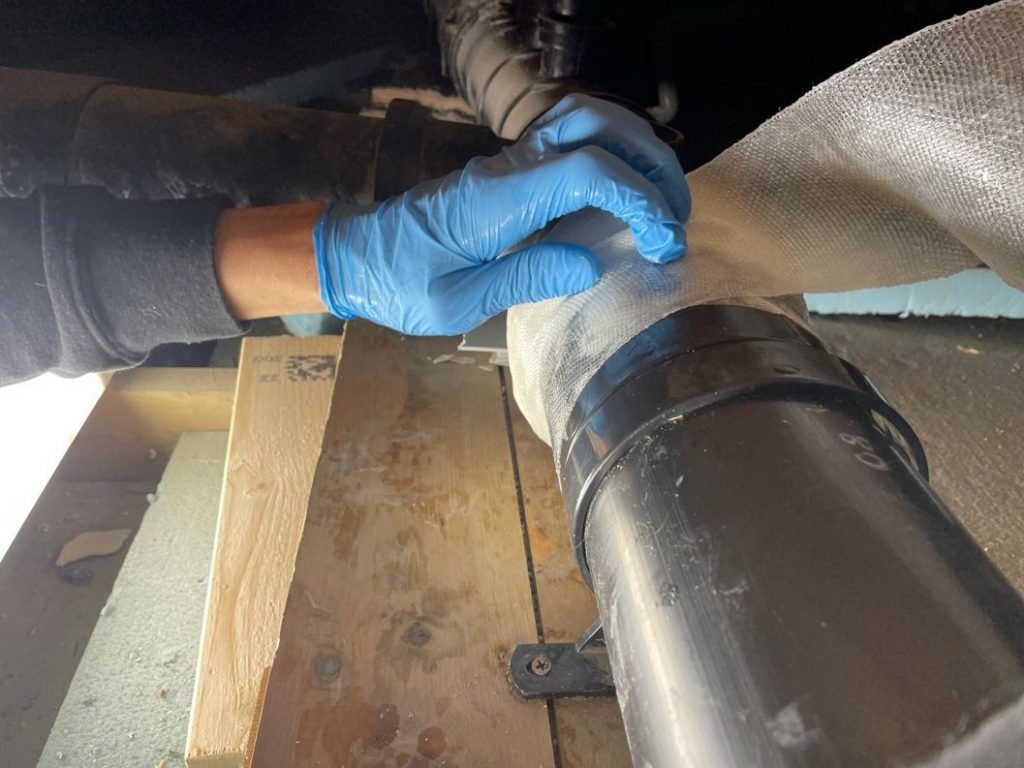 SylWrap HD Pipe Repair Bandage wrapped around a leaking plastic pipe joint to seal it
